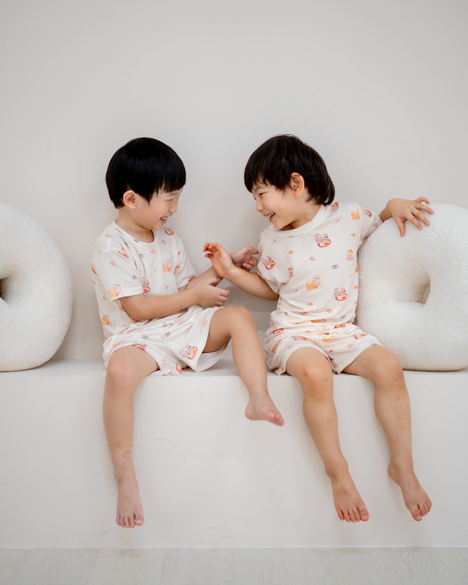 Two boys laughing and playing while wearing LeBear Kaya Butter Toast Kids TENCEL™ Lounge Set.