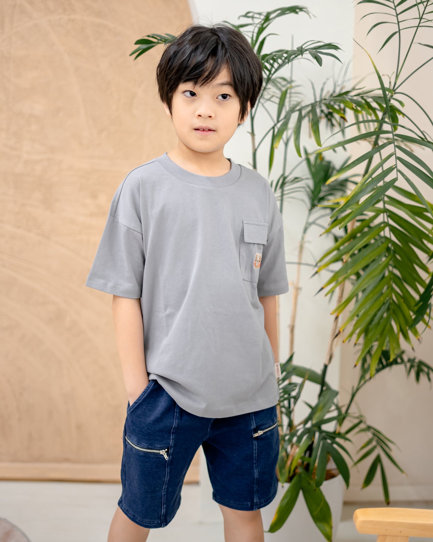 Boy wearing dark wash denim shorts with soft and slightly stretchable fabric, stylish kidswear for daily comfort