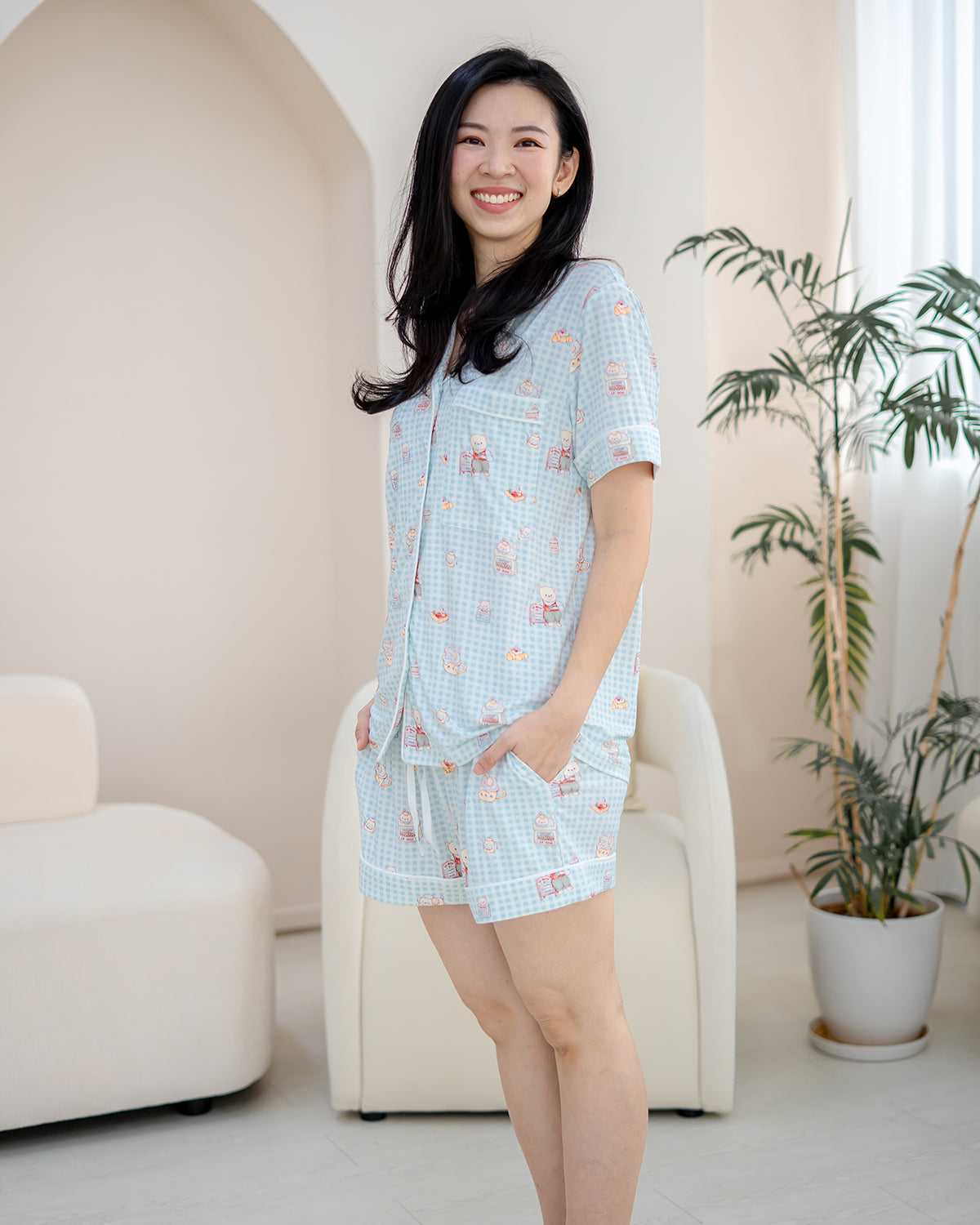 Woman wearing LeBear Bearista Bluebell adult bamboo pyjamas in breathable bamboo fabric with exclusive café-inspired teddy bear illustrations.