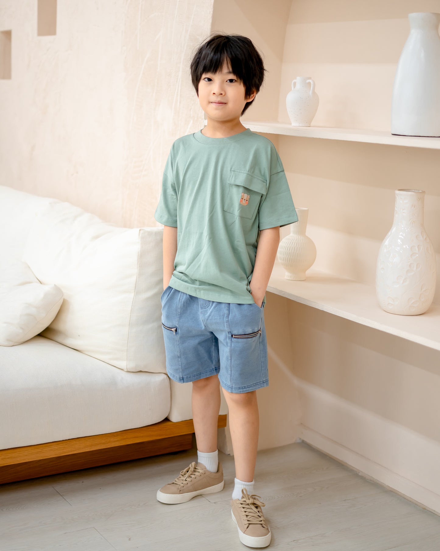 Boy model in LeBear light wash denim shorts, soft stretchable cotton denim with functional zipper pockets