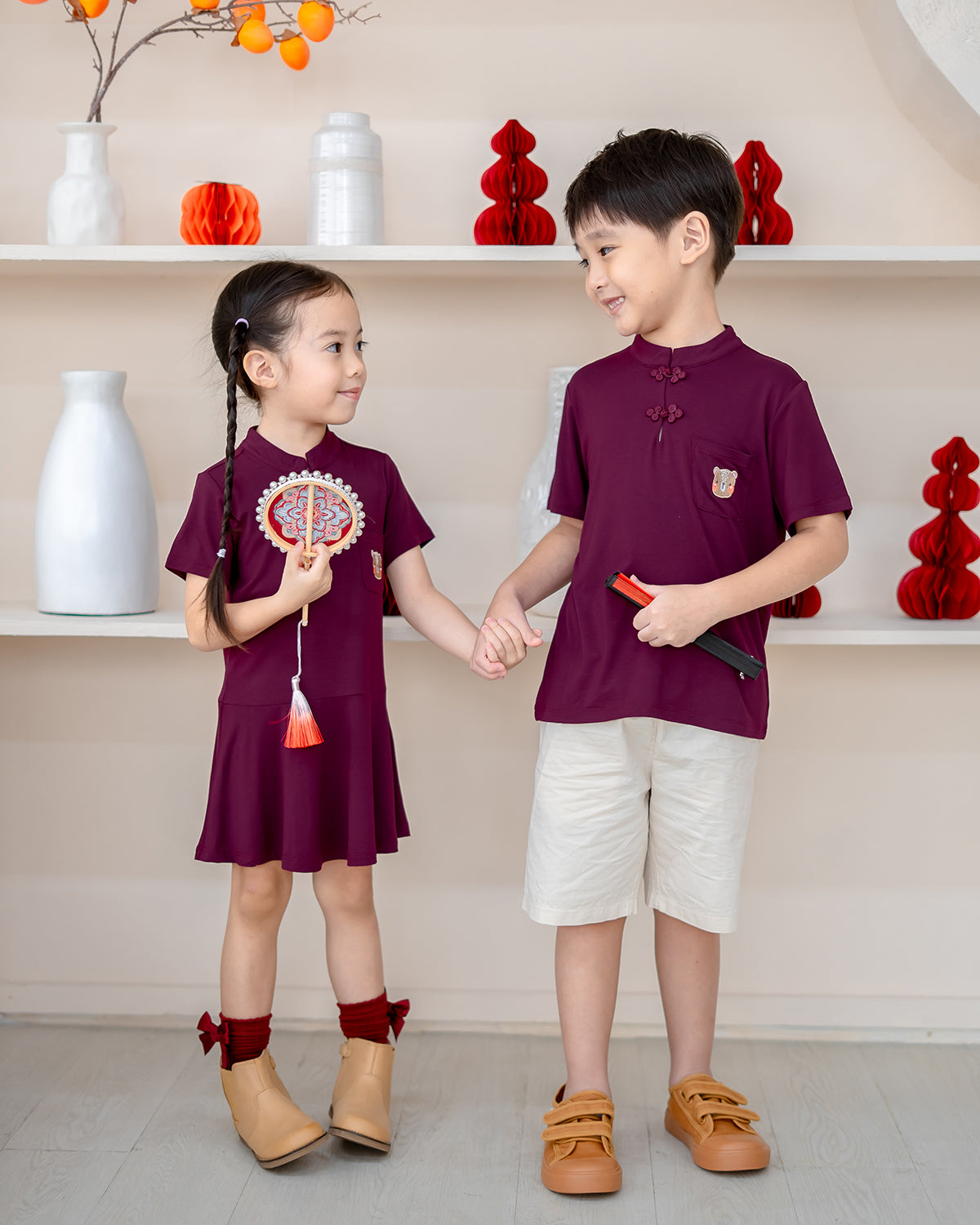 Siblings in matching Plum Blossom outfits – kids CNY family wear