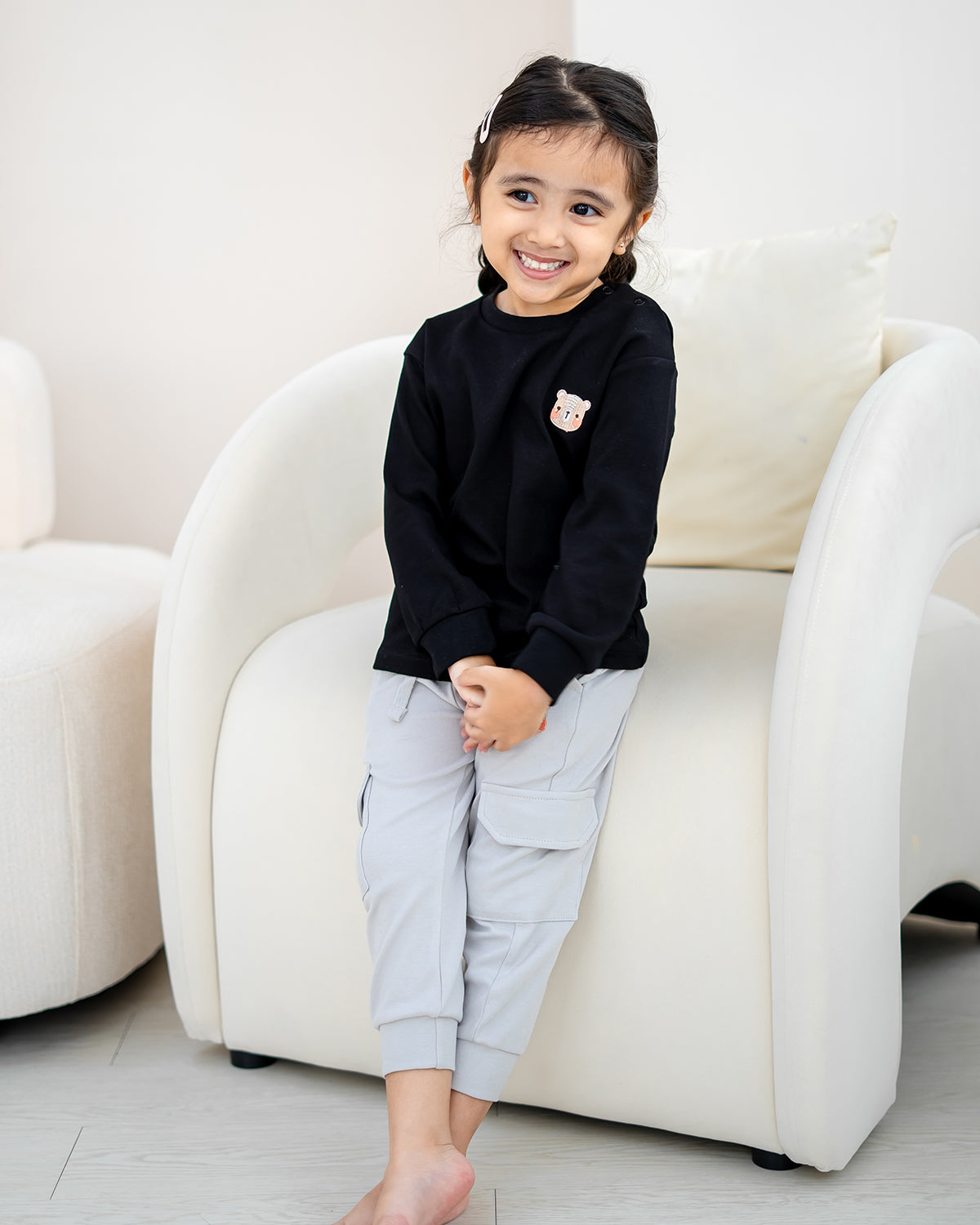 Child wearing LEBEAR Signature Embroidery Long Sleeve Tee in Black made from 100% premium cotton.