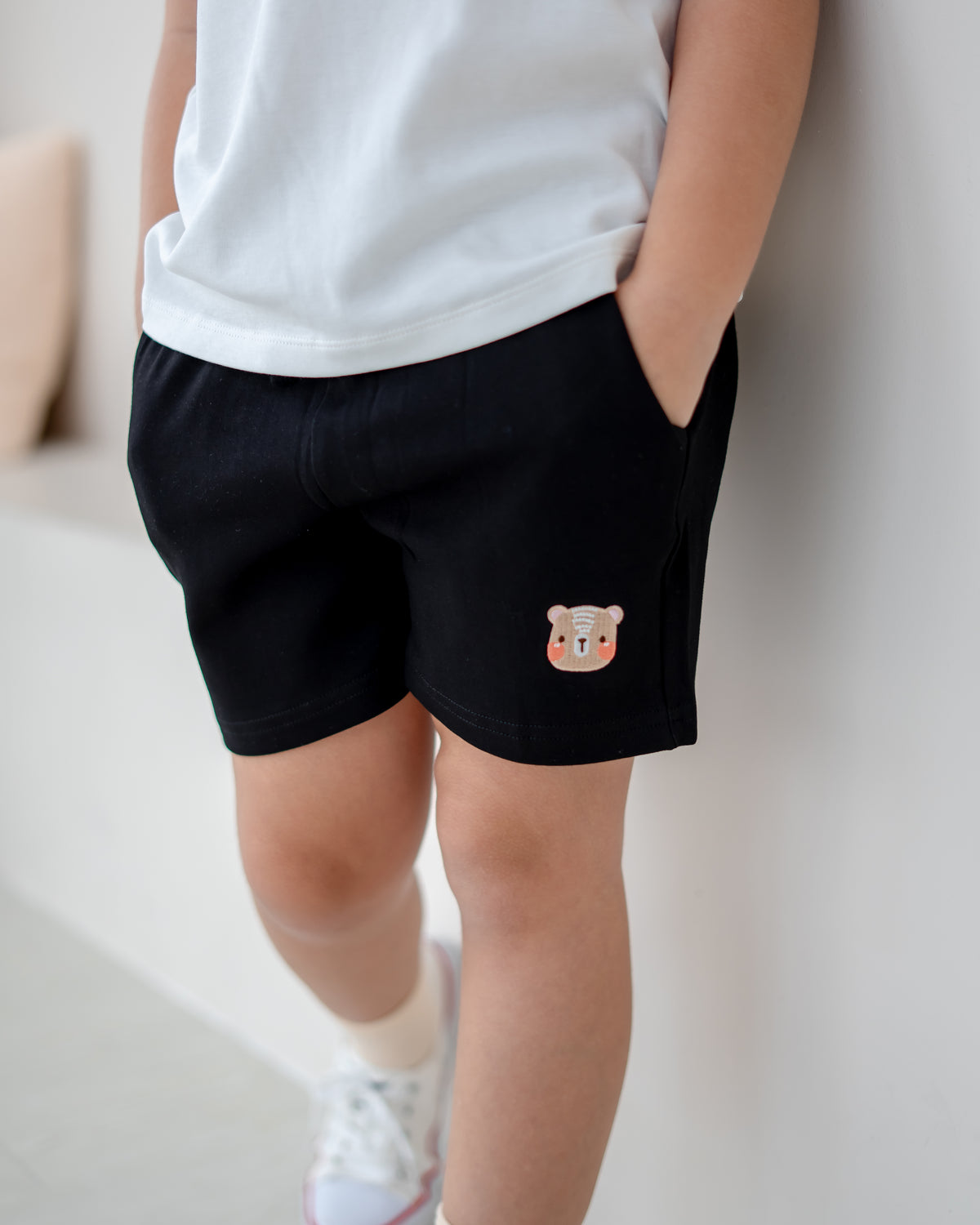 Close-up of LeBear Signature black jogger shorts with bear embroidery
