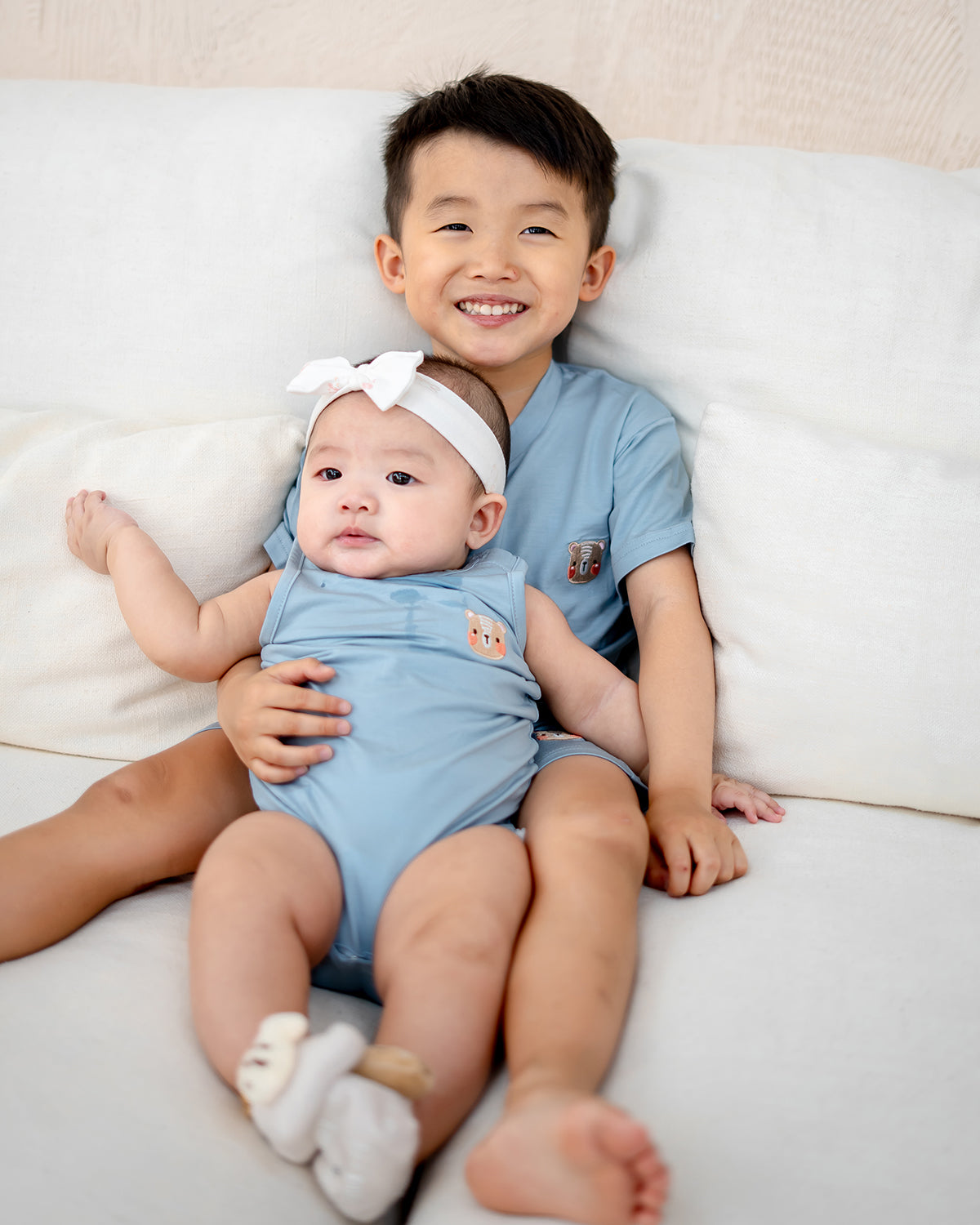 Family wearing LEBEAR matching TENCEL™ apparel in navy and sky blue for cozy home moments.