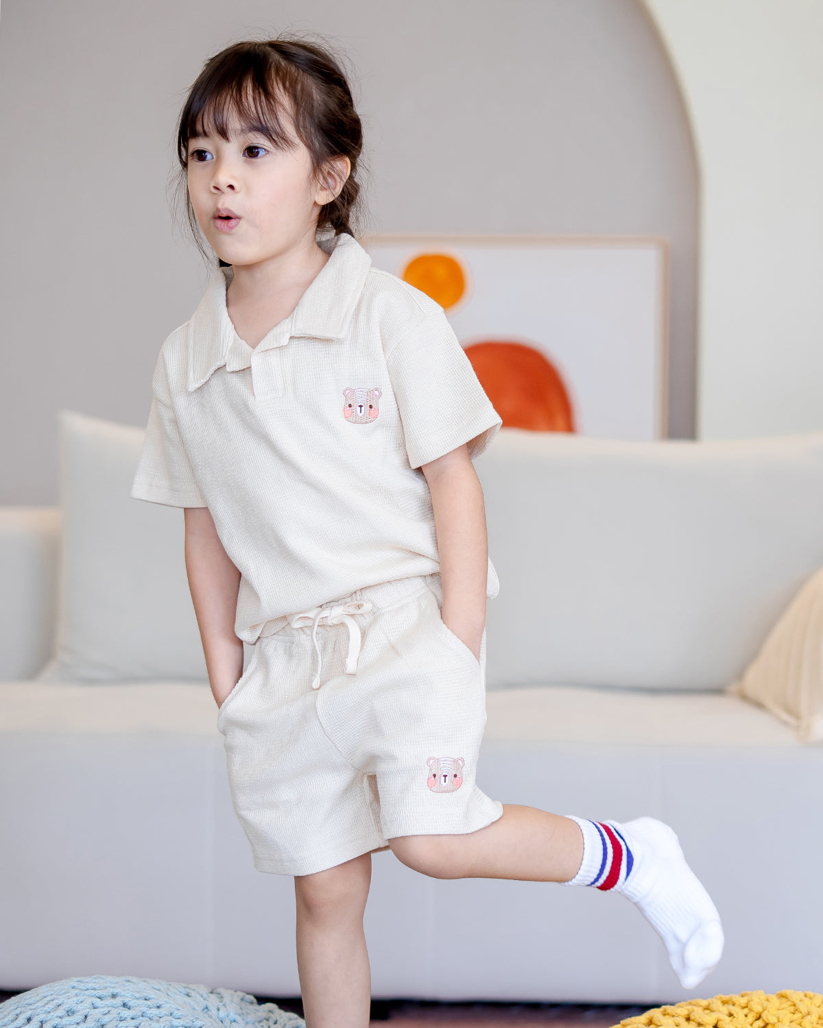 Child wearing LeBear waffle cotton unisex set in beige, featuring fluffy bear embroidery on top and shorts