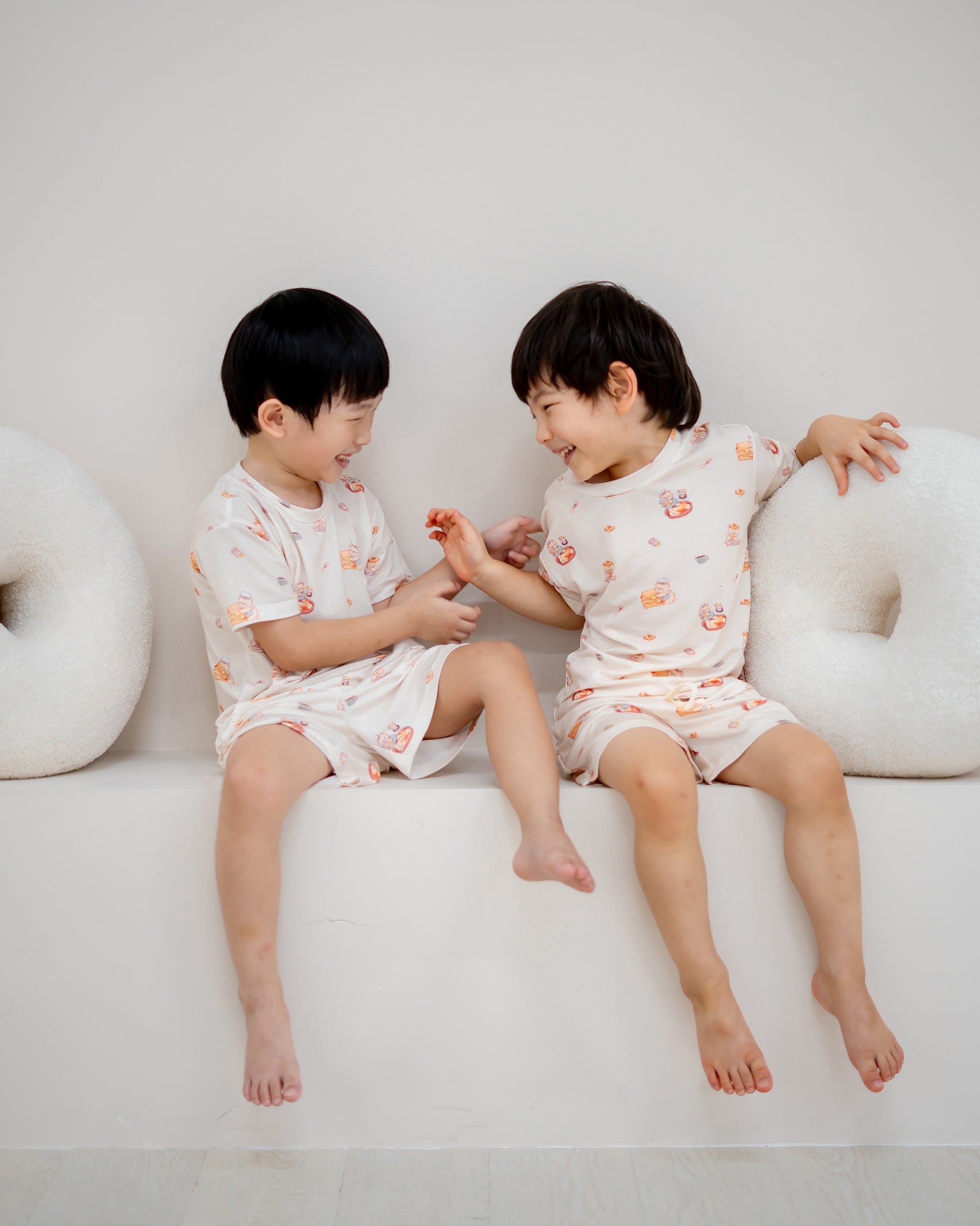 Two boys laughing and playing while wearing LeBear Kaya Butter Toast Kids TENCEL™ Lounge Set.