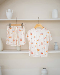 LeBear Kaya Butter Toast Kids TENCEL™ Lounge Set displayed on hanger featuring matching short sleeve top and shorts with breakfast print.