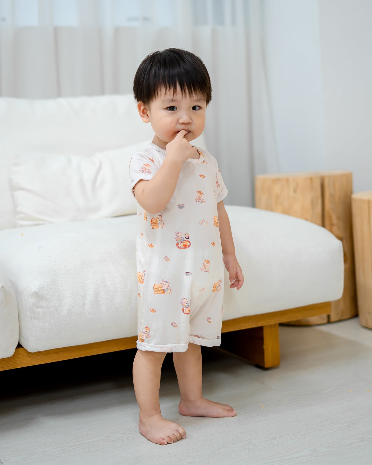 Toddler standing in LeBear Kaya Butter Toast TENCEL™ Baby Onesie with soft premium comfort and cute kaya toast print.