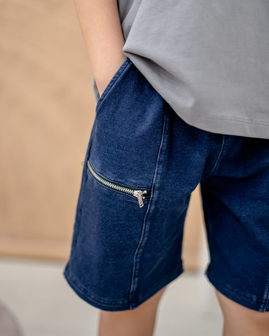 Close-up of dark wash denim shorts with zipper pocket, soft and slightly stretchable kids denim for everyday wear