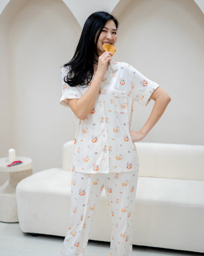 Woman wearing LeBear Adult Kaya Butter Toast Bamboo Pyjamas Pants Set holding toast in playful home setting.