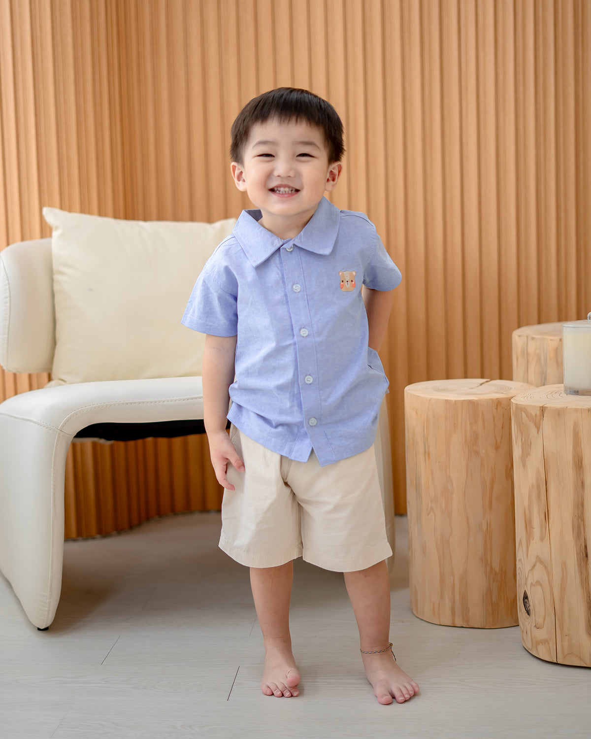 Boy standing in LeBear Atelier Short Sleeve Button Down Shirt Blue