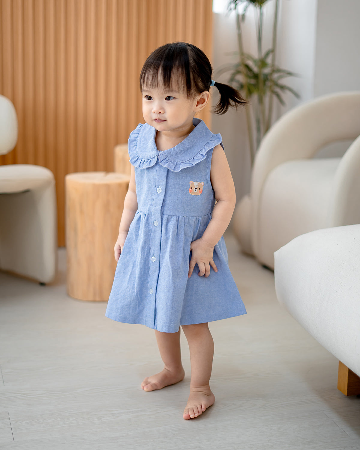 “Baby girl wearing LeBear Atelier Ruffle Collar Dress in Blue – 100% cotton front view”