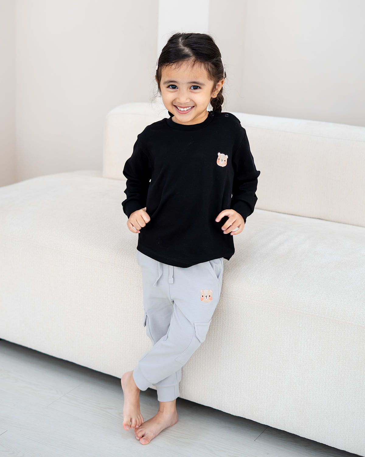 Front view of LEBEAR Signature Embroidery Long Sleeve Tee in Black for kids with signature bear embroidery.