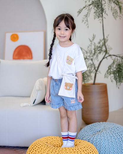 Girl wearing LeBear Fluffy Embroidery Kids Tee with bear sling bag and denim shorts – playful and cozy outfit by LeBear Singapore.