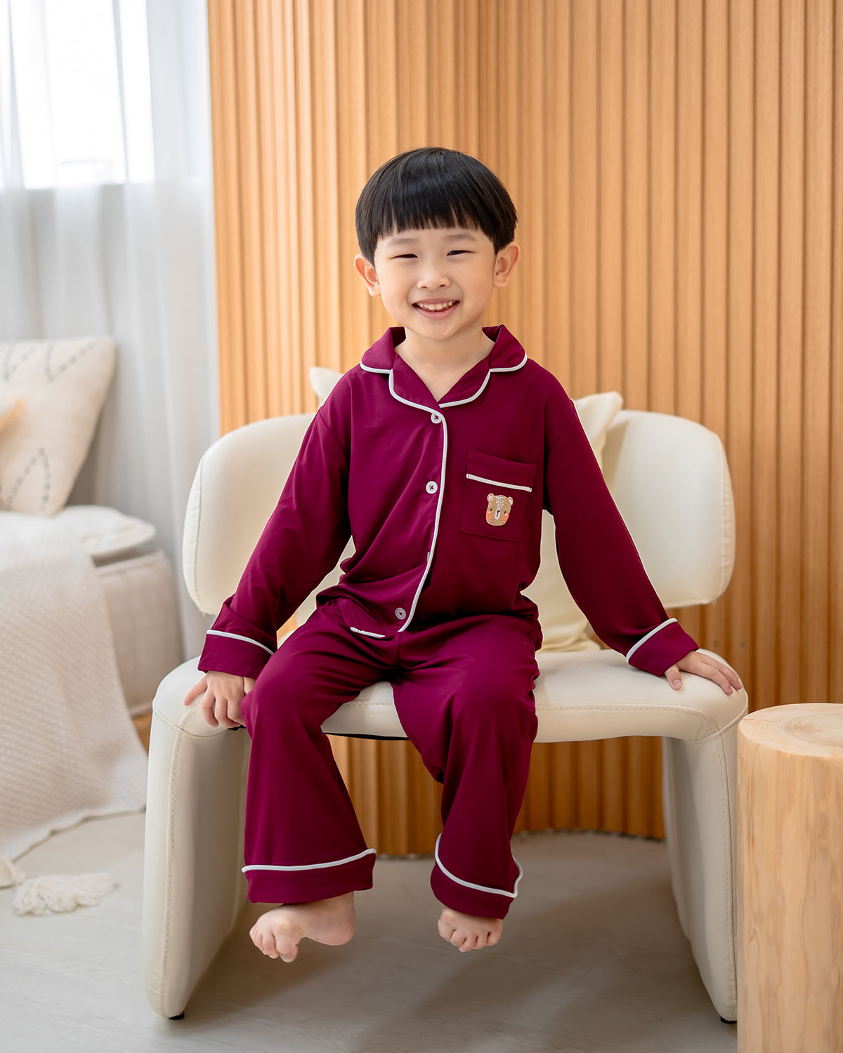 Child smiling in OEKO-TEX certified bamboo pyjamas with LeBear embroidered bear pocket