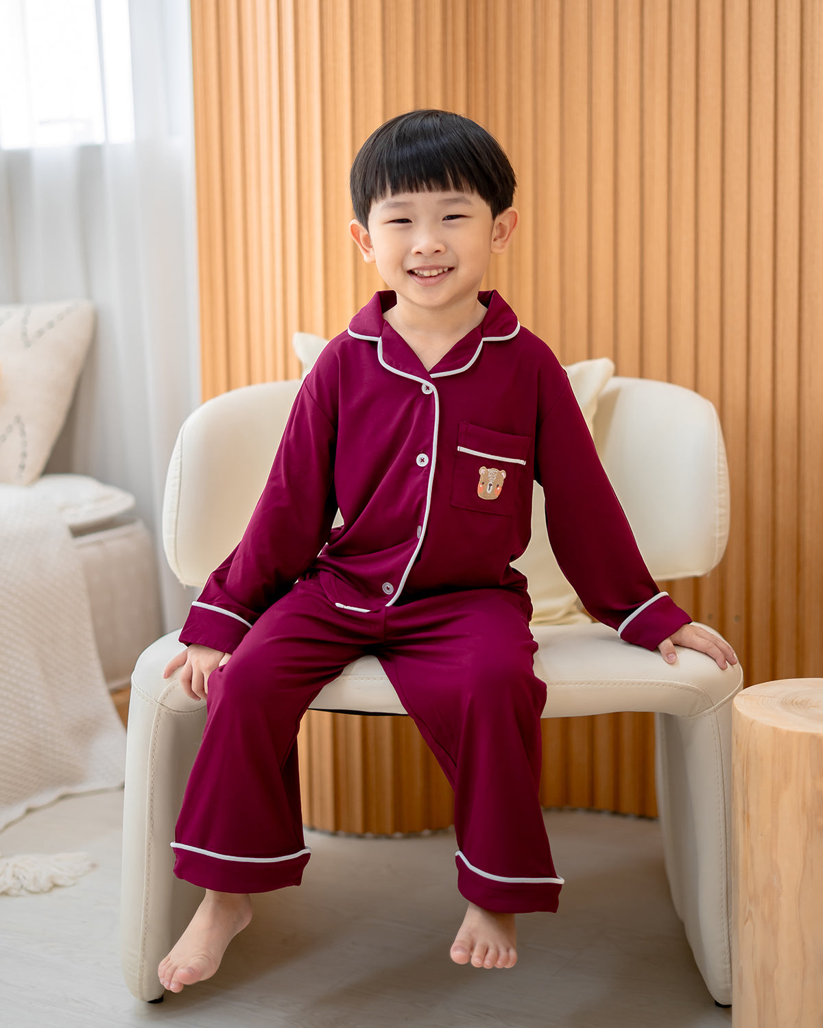 Child relaxing while wearing LeBear bamboo Luxe Comfort pyjamas in wine red