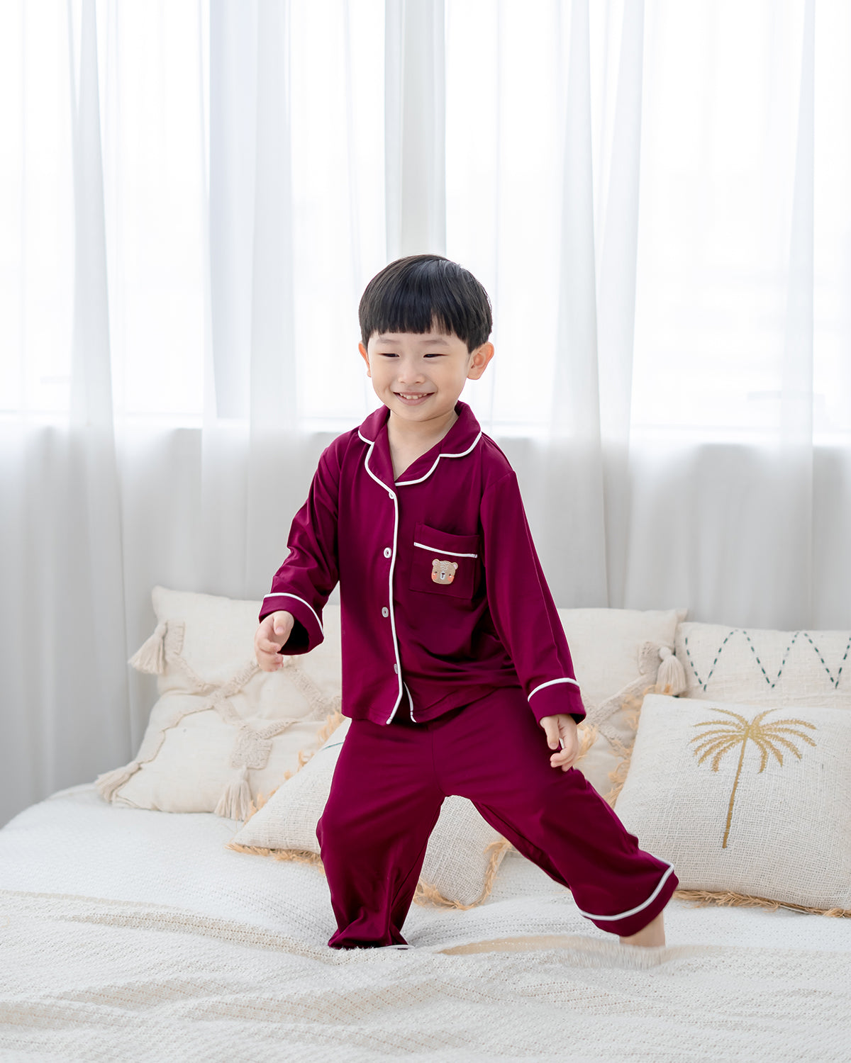 Child wearing OEKO-TEX certified bamboo kids pyjamas in wine red by LeBear