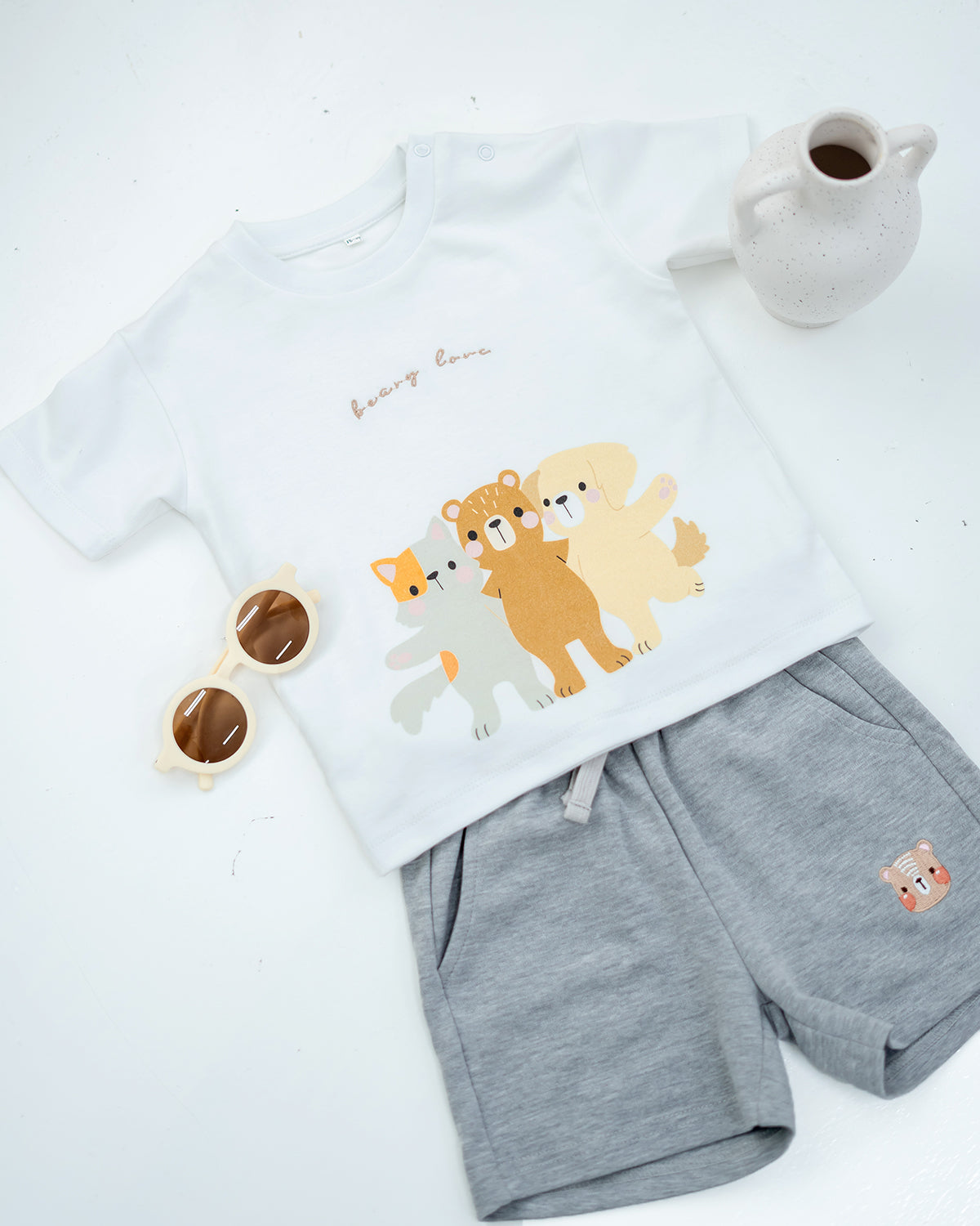 LeBear Kids Bear Friends Tee in white paired with grey bear embroidered shorts, flat lay outfit styling