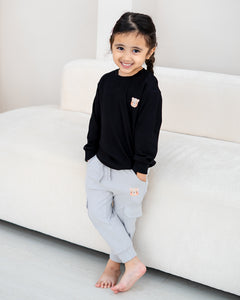 Child modelling the LEBEAR Signature Embroidery Long Sleeve Tee in Black with matching cargo joggers.