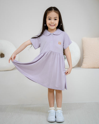 Girl smiling in LeBear Kids TENCEL™ Collar Dress in Lilac holding out skirt to show flowy drape and comfort.