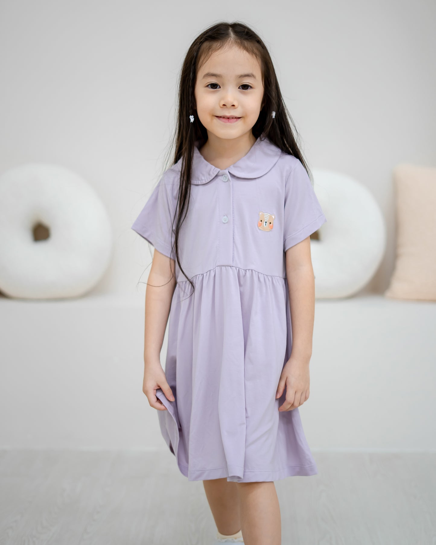 Child walking in LeBear Kids TENCEL™ Collar Dress in Lilac featuring signature bear embroidery and rounded collar.