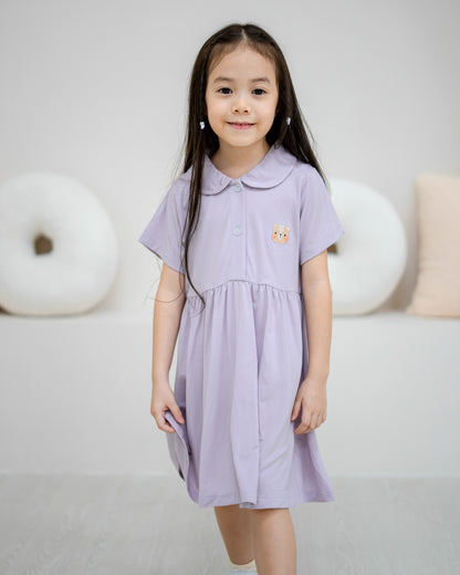 Child walking in LeBear Kids TENCEL™ Collar Dress in Lilac featuring signature bear embroidery and rounded collar.