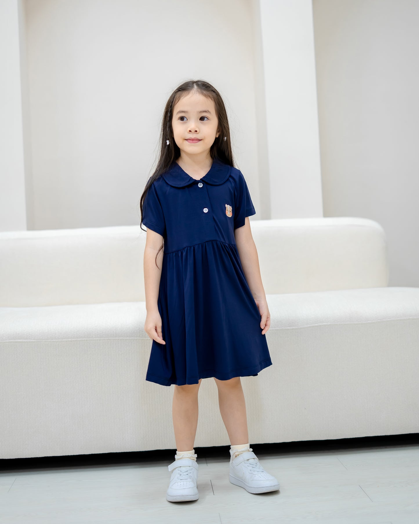 Child standing in LeBear Kids TENCEL™ Collar Dress in Navy showcasing flowy silhouette and premium comfort.
