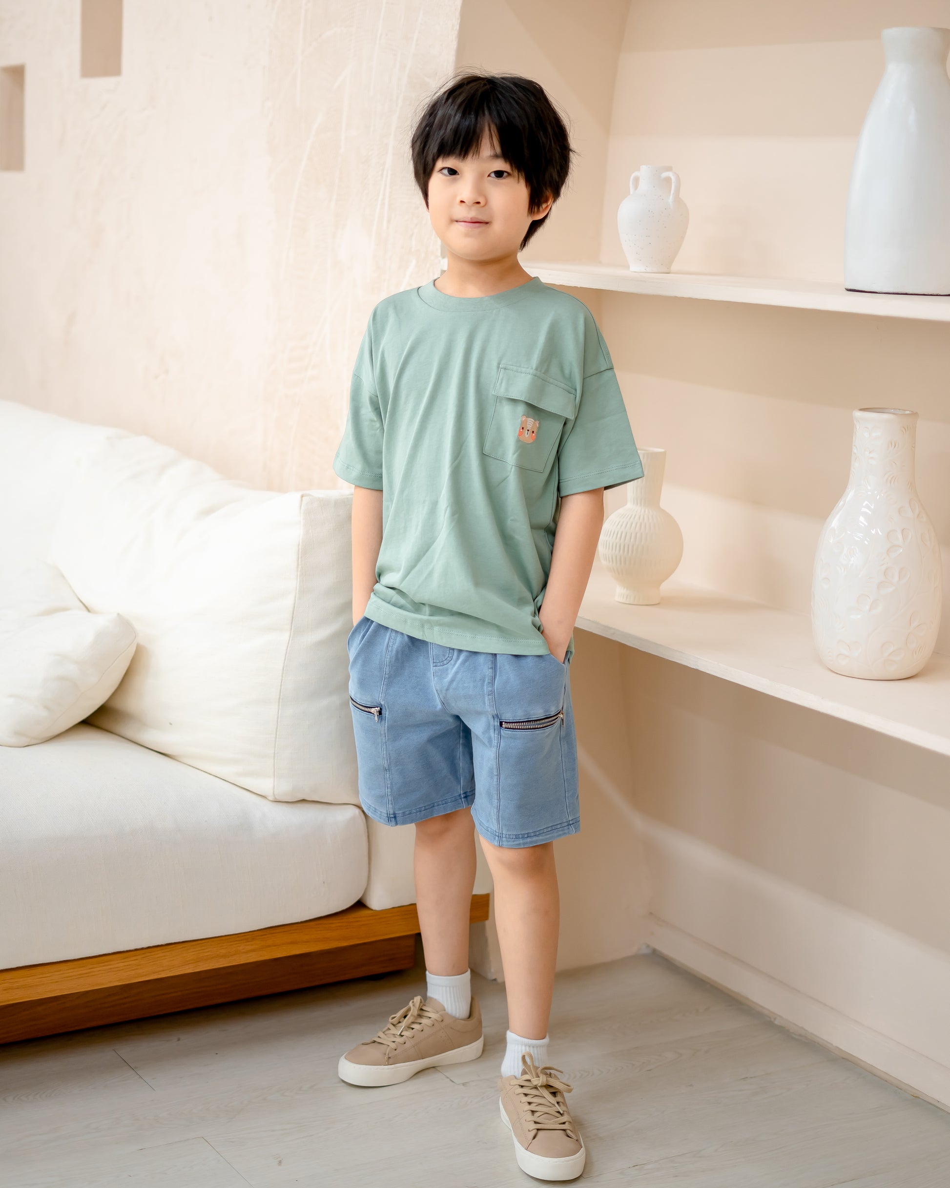 Boy model in LeBear light wash denim shorts, soft stretchable cotton denim with functional zipper pockets