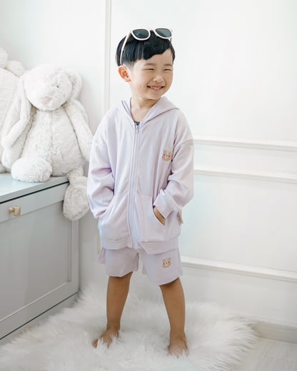 Smiling boy in LeBear lilac premium cotton hooded jacket and shorts set, casual kidswear look