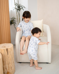 Kids wearing matching LeBear Meadow Blue TENCEL sets in a bright home setting