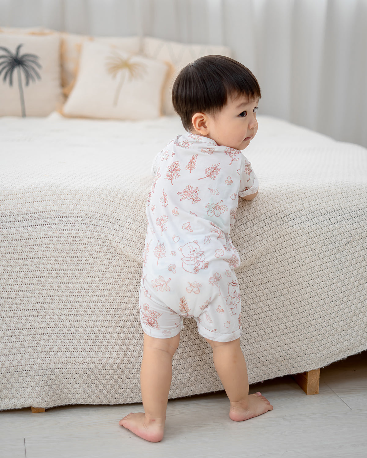 Back view of baby in LeBear Meadow Mocha TENCEL romper showing soft neutral print