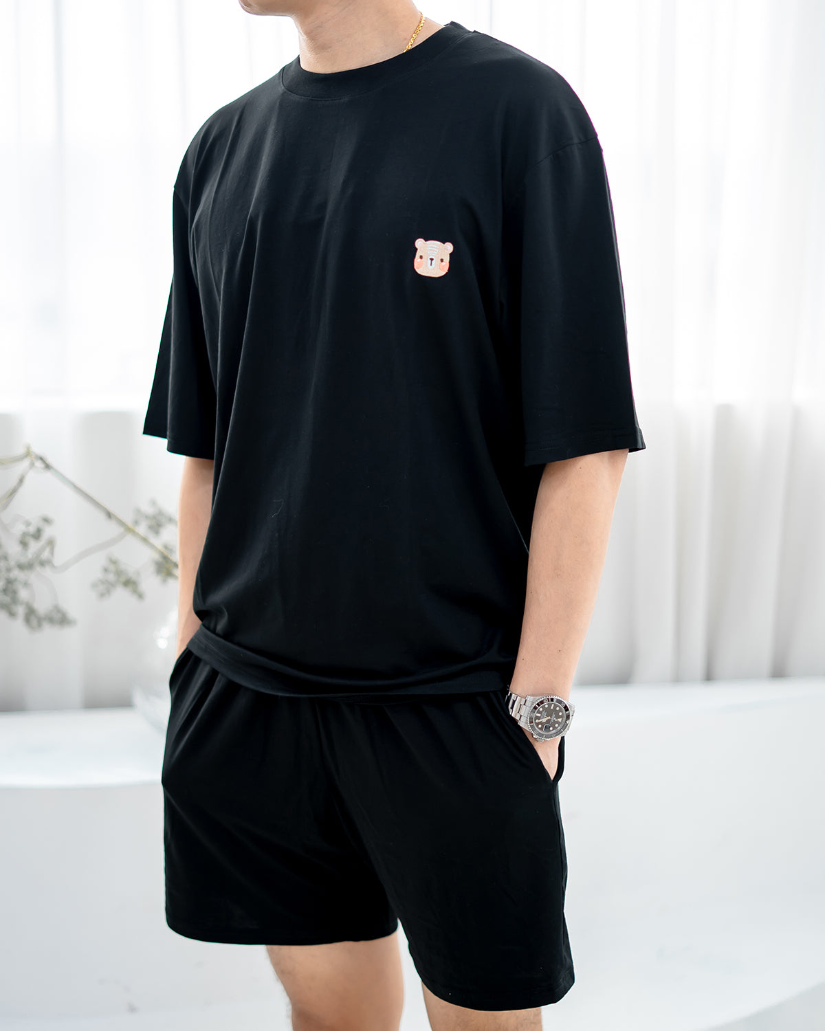 Close-up of signature LEBEAR bear embroidery on men’s TENCEL™ black tee.