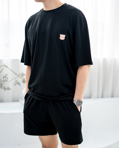 Close-up of signature LEBEAR bear embroidery on men’s TENCEL™ black tee.