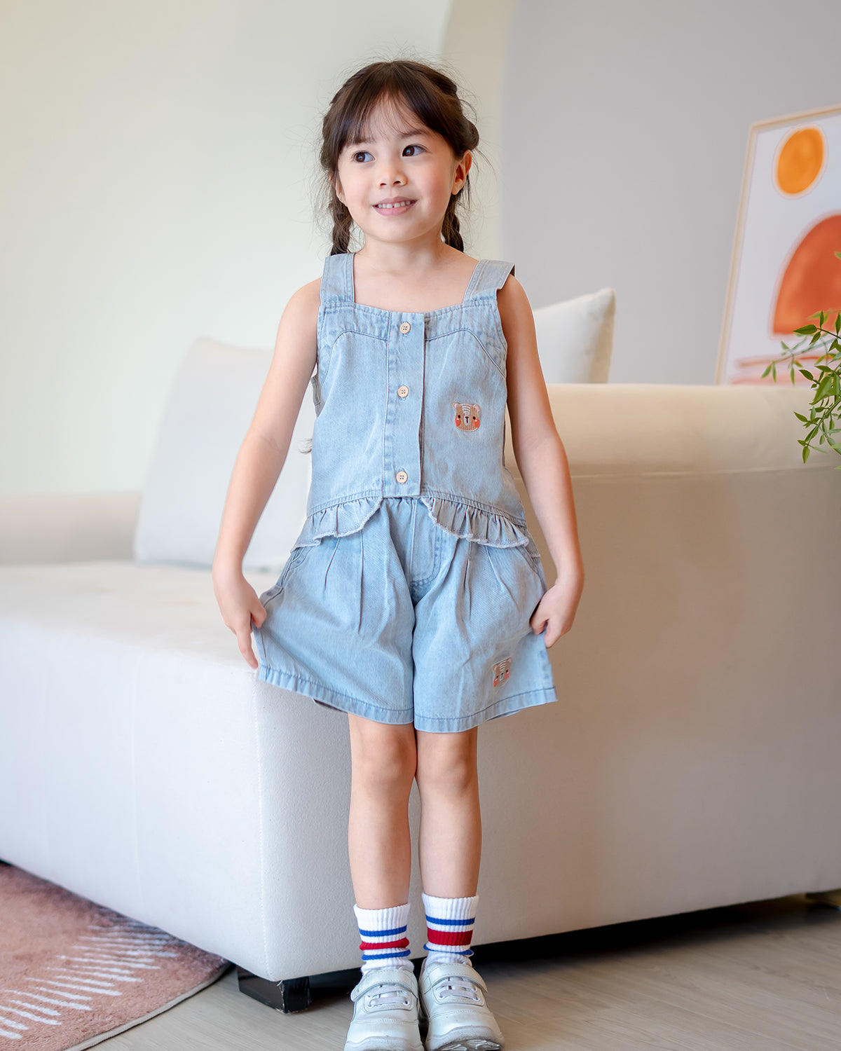 Girl wearing LeBear Mia Ruffle Denim Set made from 100% premium cotton with button-down top and bear embroidery