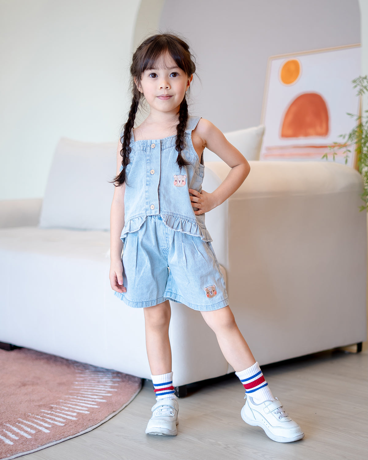 Child smiling in LeBear Mia Ruffle Denim Set, soft lightweight denim cotton outfit with ruffle detailing