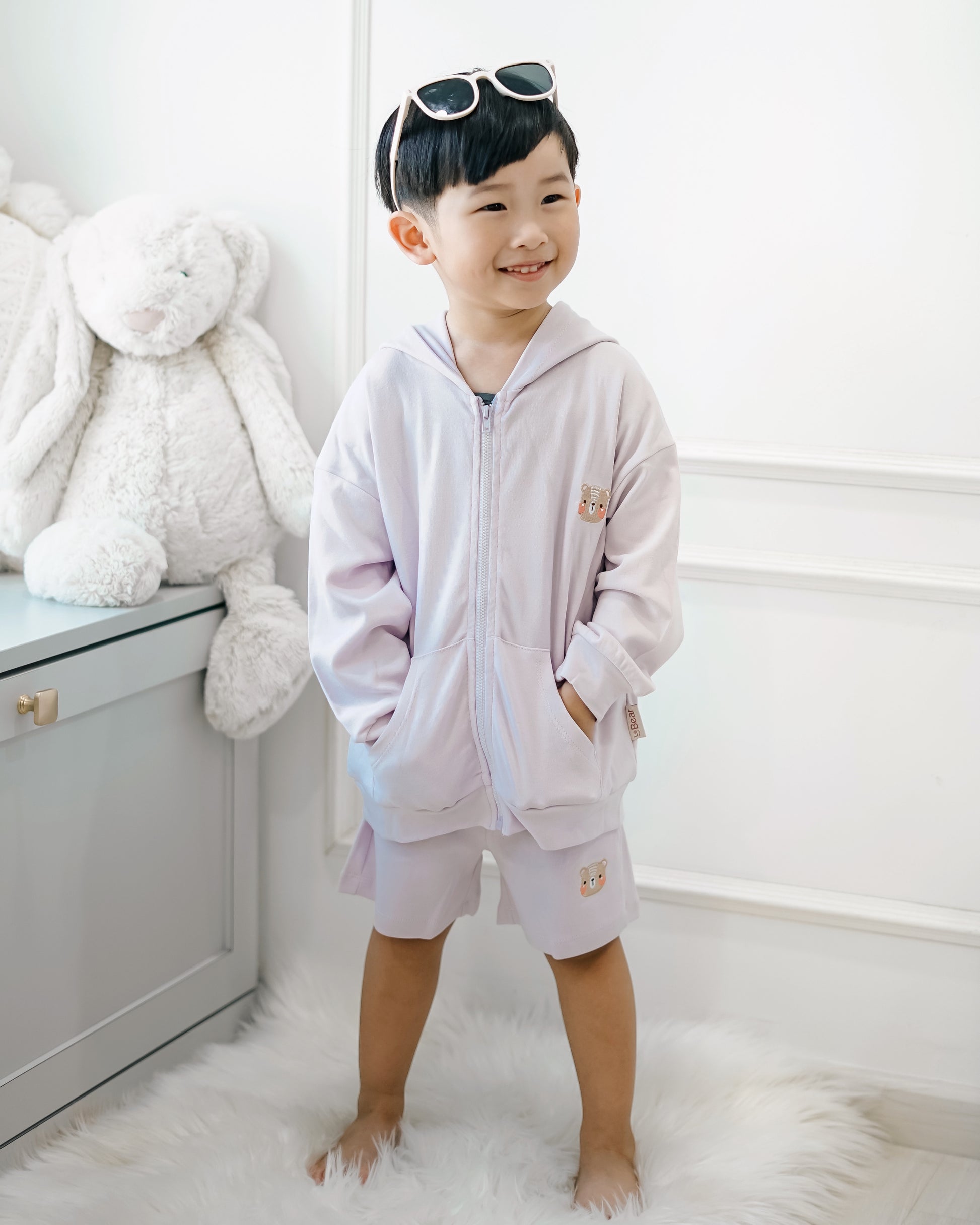 Boy wearing LeBear premium cotton lilac hooded jacket with front zip and bear embroidery, styled with matching shorts
