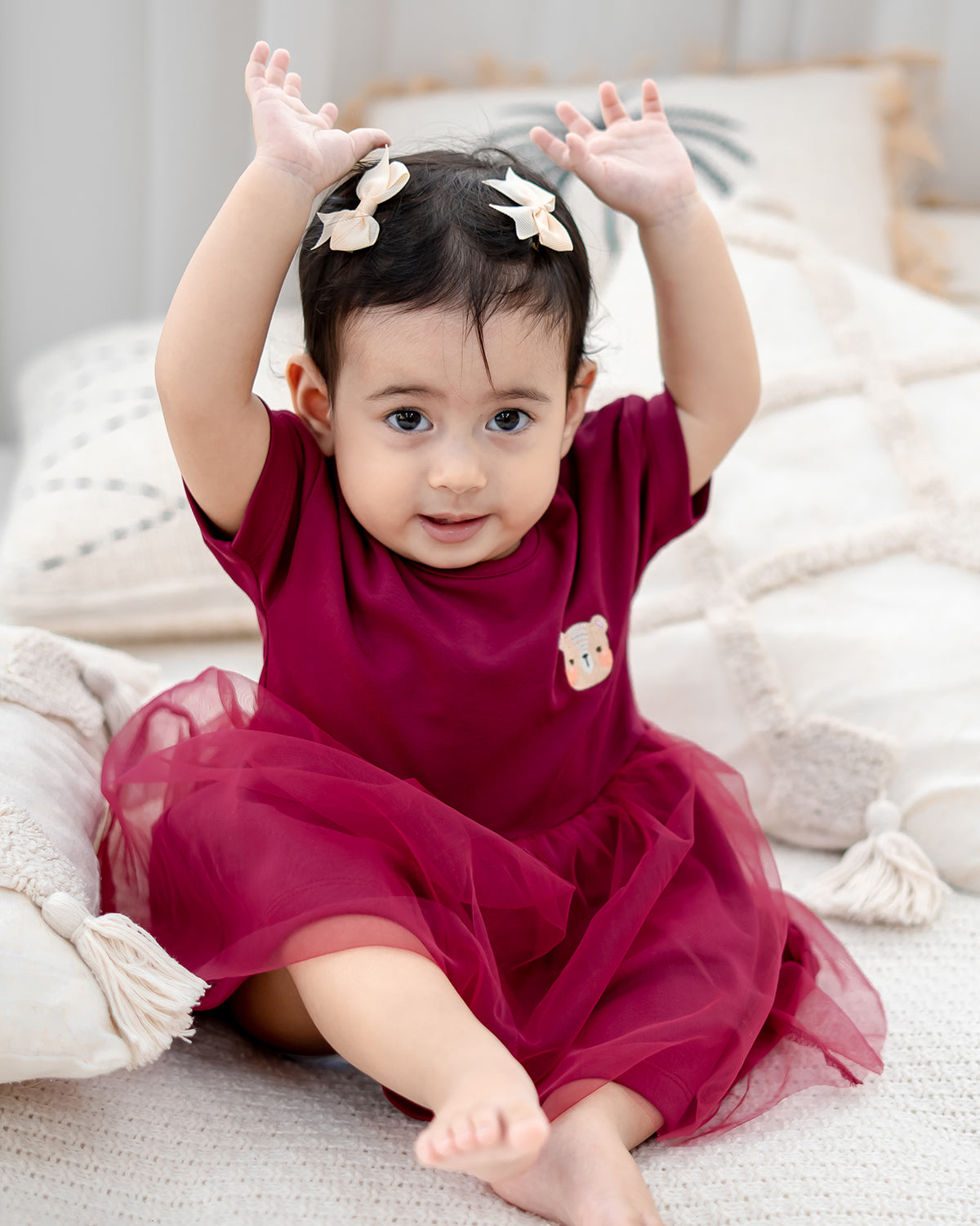 toddler wearing lebear roselle tulle dress sitting on bed