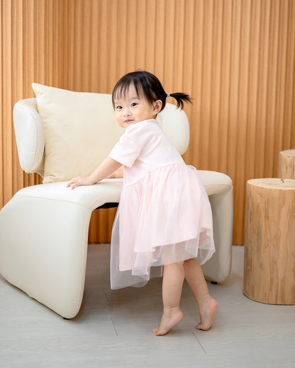 “Side view of toddler in LeBear Roselle Tulle Dress Blush Pink with layered tulle skirt”