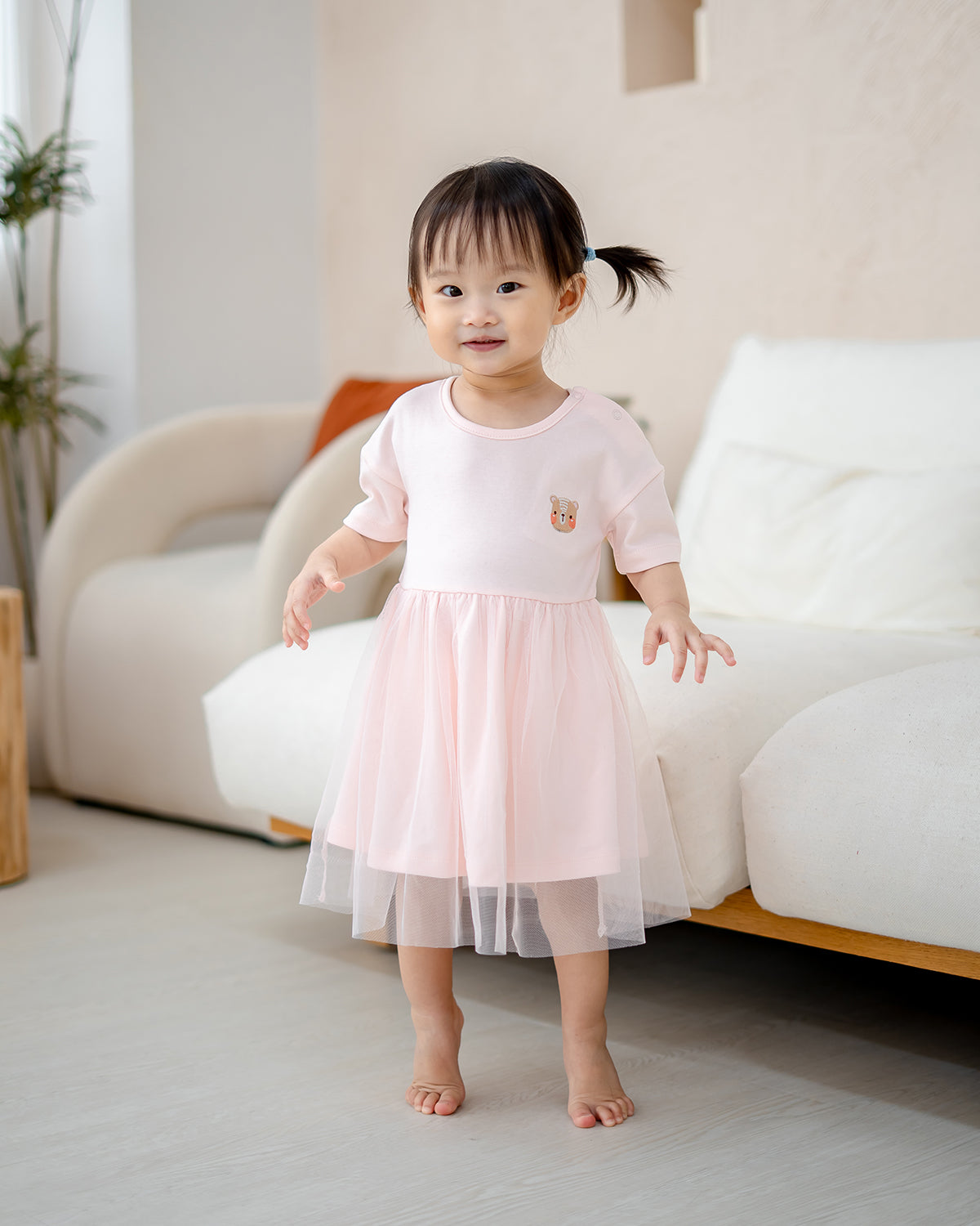 “Full body front view of baby girl in LeBear Roselle Tulle Dress Blush Pink”
