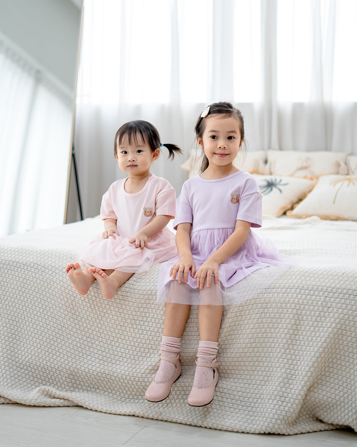 “Two girls wearing LeBear Roselle Tulle Dress in Lilac Mist and Blush Pink – premium kids tulle dress Singapore”