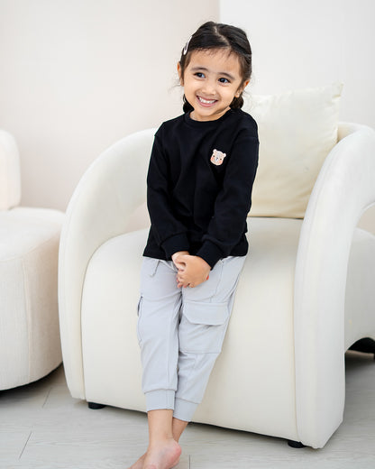 Child wearing LEBEAR Signature Embroidery Long Sleeve Tee in Black made from 100% premium cotton.