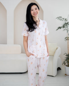 Woman wearing LeBear Sweet Scoop adult bamboo pyjamas in soft pink gingham with exclusive teddy bear and ice cream illustrations.