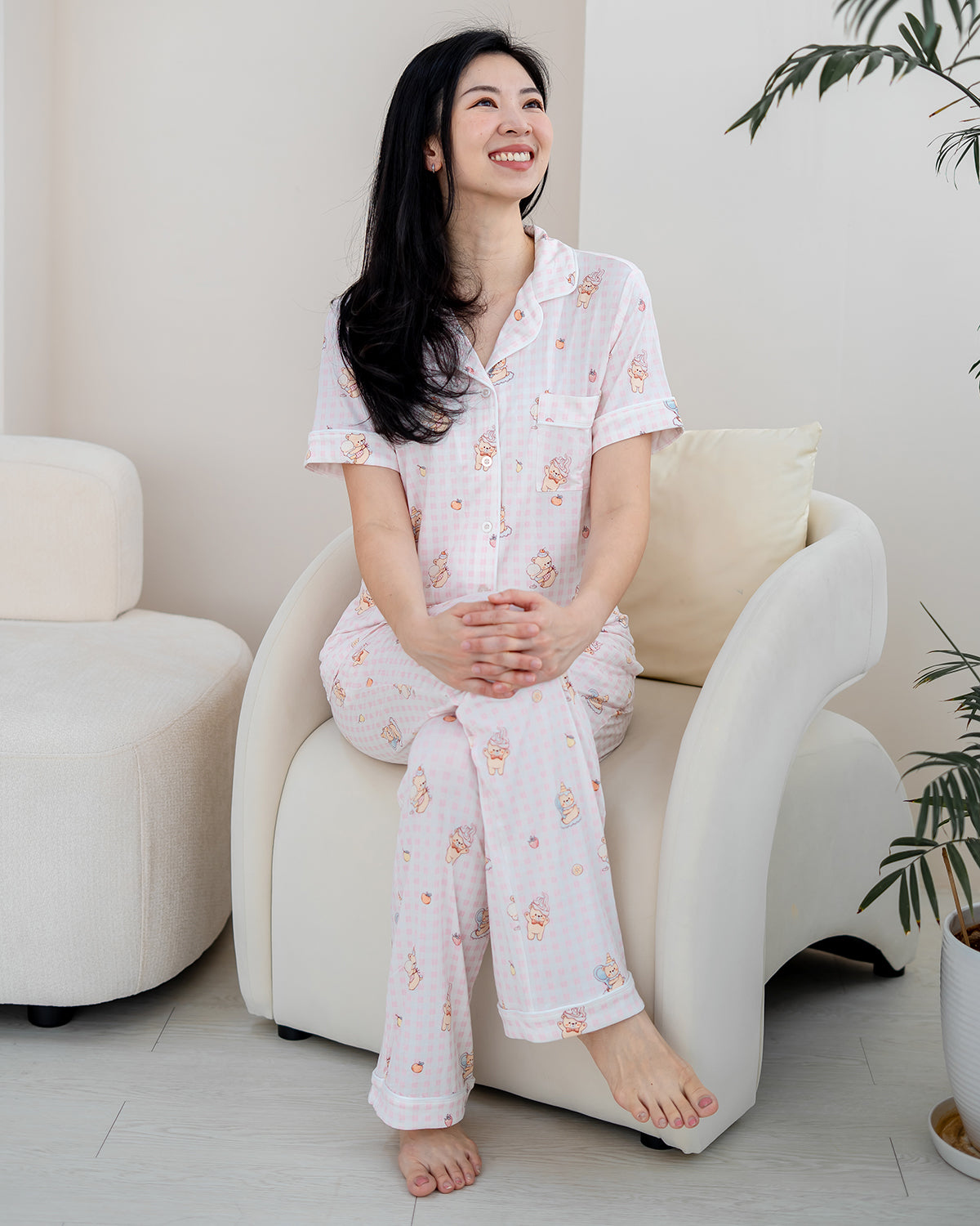 Woman relaxing in LeBear Sweet Scoop adult bamboo pyjamas with breathable bamboo fabric and signature ice cream teddy bear print.