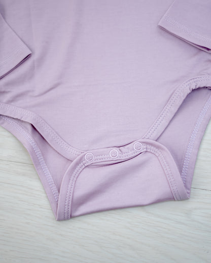 Bottom snap closure detail on LEBEAR TENCEL™ Lilac long sleeve bodysuit — gentle and practical baby wear.