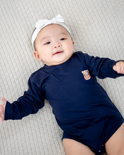 Close-up of LEBEAR TENCEL™ Navy baby romper with signature bear embroidery detail.