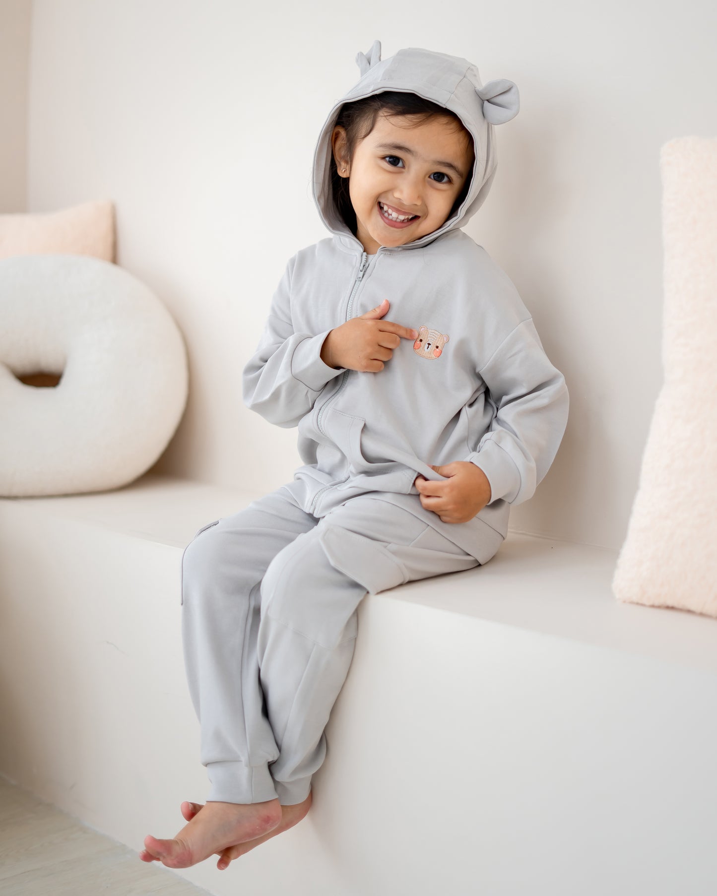 Side view of child wearing LeBear Voyabear cotton hoodie in cloud grey