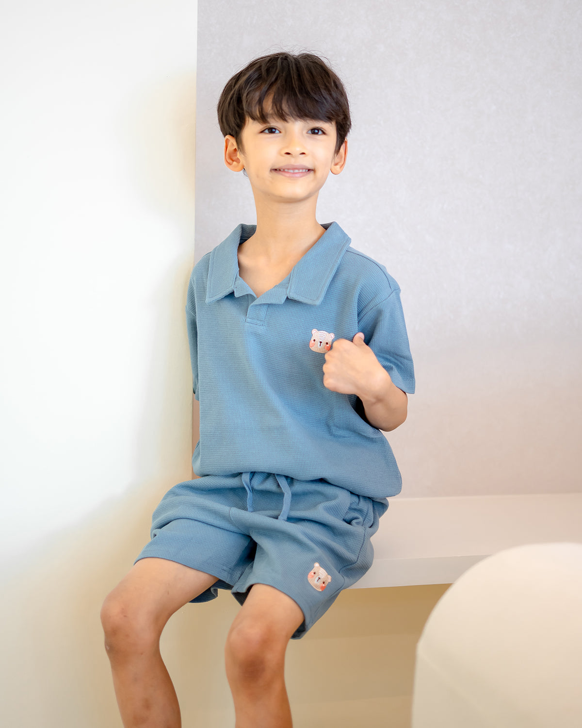 Child smiling in LeBear blue waffle collar top and shorts, breathable premium cotton outfit for kids