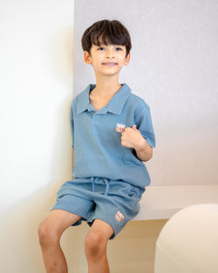 Child smiling in LeBear blue waffle collar top and shorts, breathable premium cotton outfit for kids