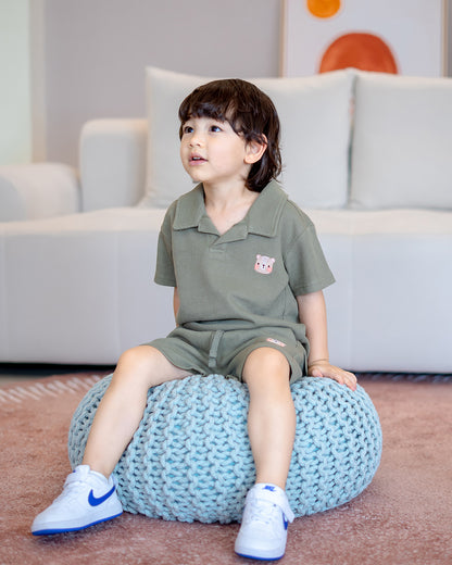 Boy sitting on knitted pouf in LeBear 100% premium cotton waffle collar set, soft and tagless kidswear
