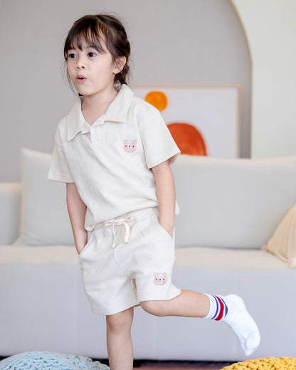 Child wearing LeBear waffle cotton unisex set in beige, featuring fluffy bear embroidery on top and shorts